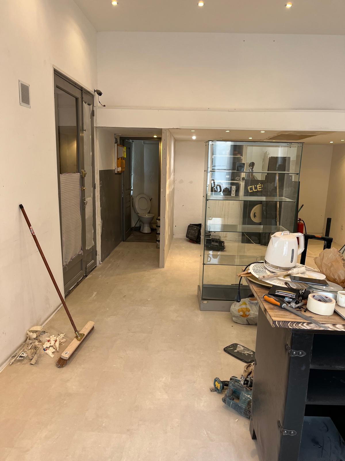Le local Maison Mégane en cours de préparation, avec le sol dégagé et les outils de chantier.