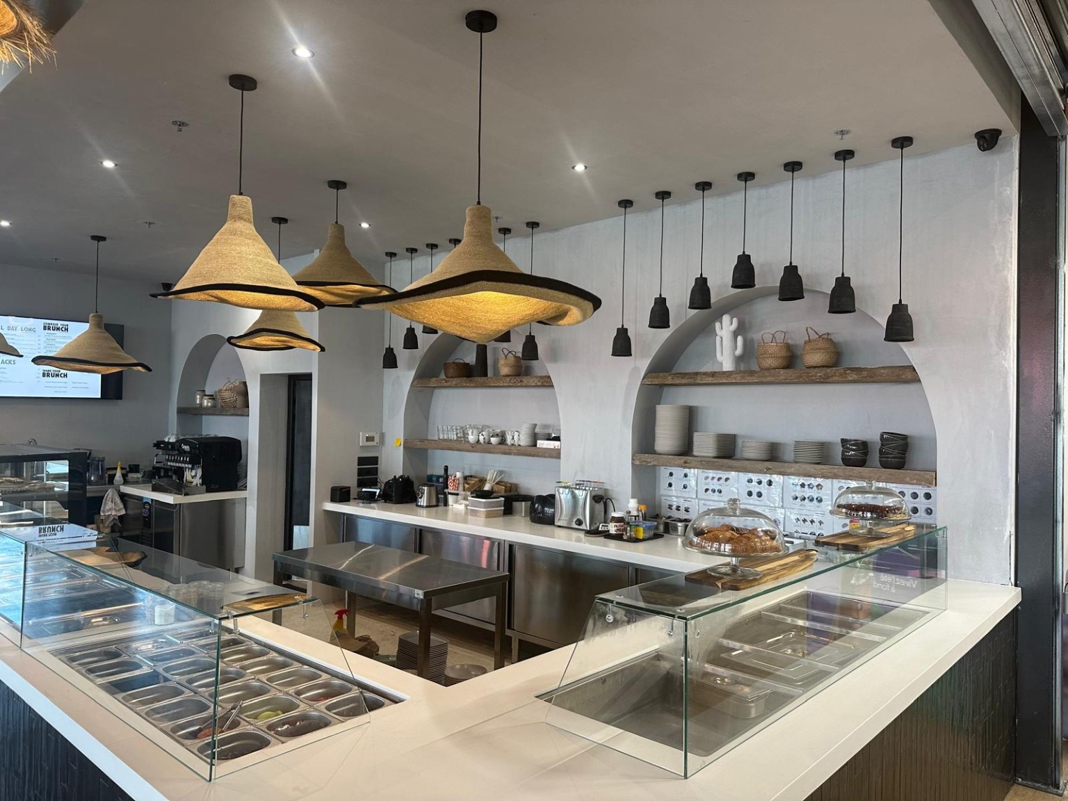Vue rapprochée du comptoir Pansy, avec les alcôves en arche, les étagères en bois et le plafond suspendu.